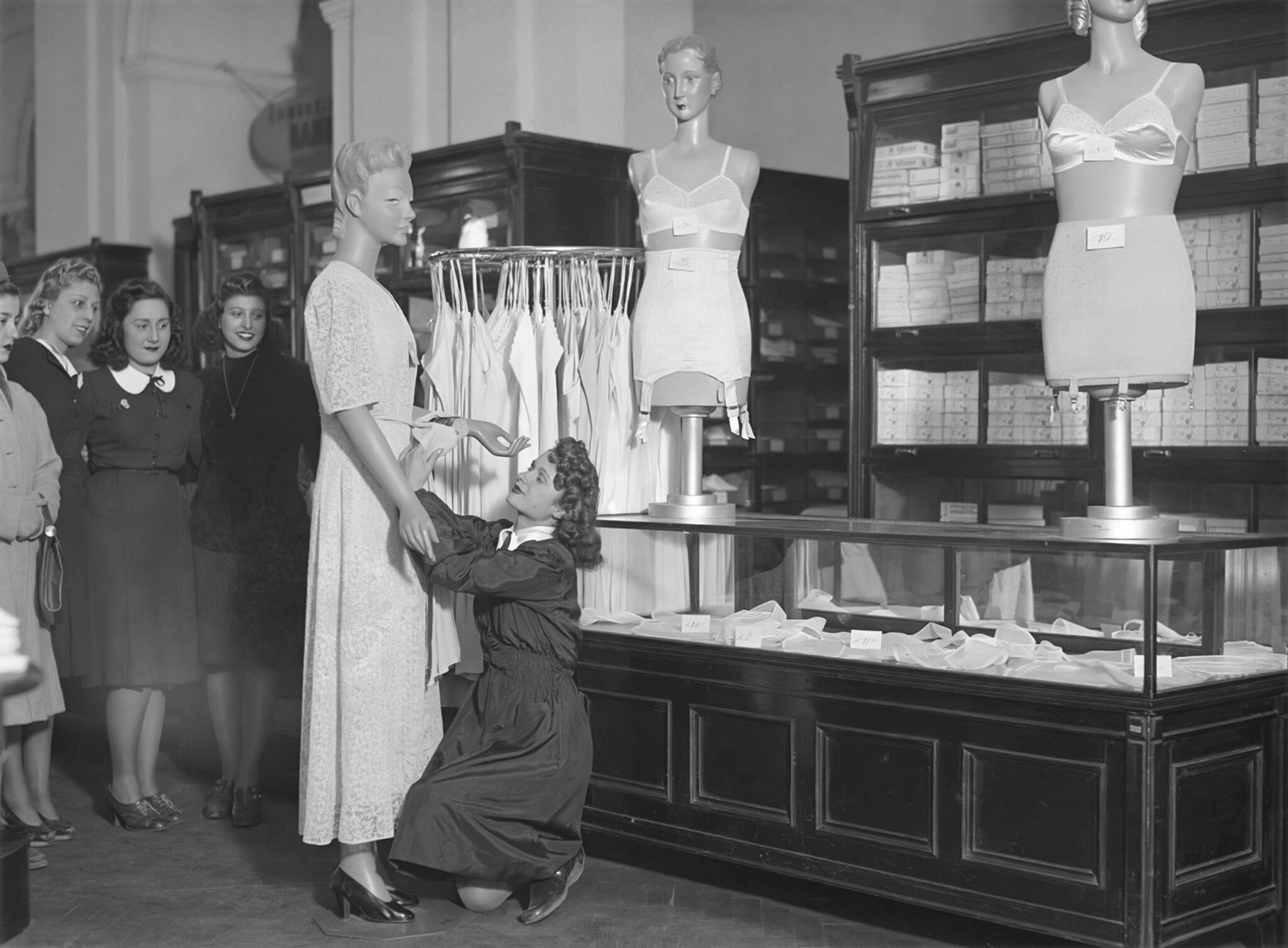 A young shop assistant sorts out a dressing gown on a dummy during a contest (1941) | Source: Archivio Luce Cinecittà