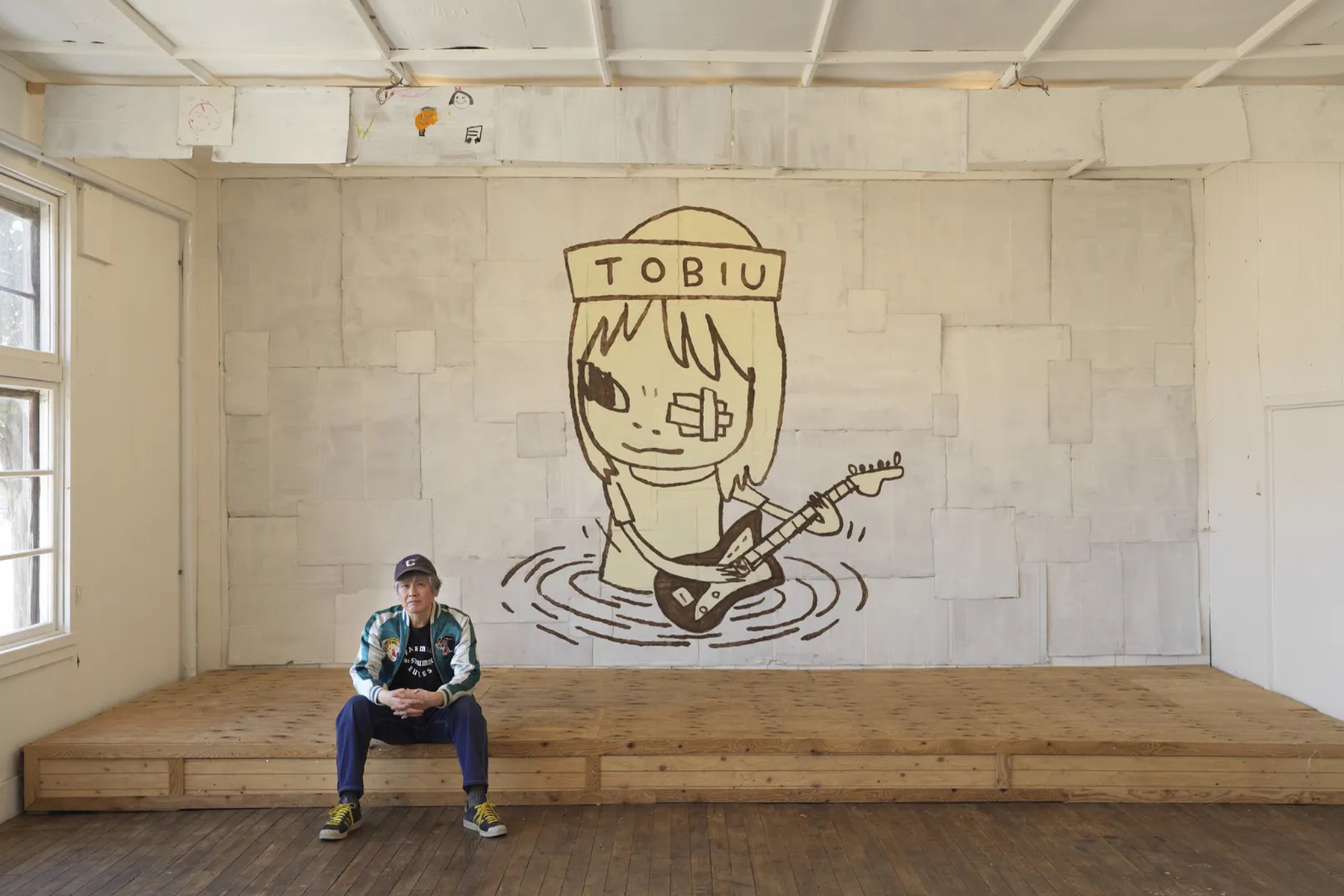 Yoshitomo Nara seated in front of TOBIU, 2019, donated by the artist to the TWO x TWO for AIDS and Art auction, 2021 | Source: Yoshitomo Nara Foundation